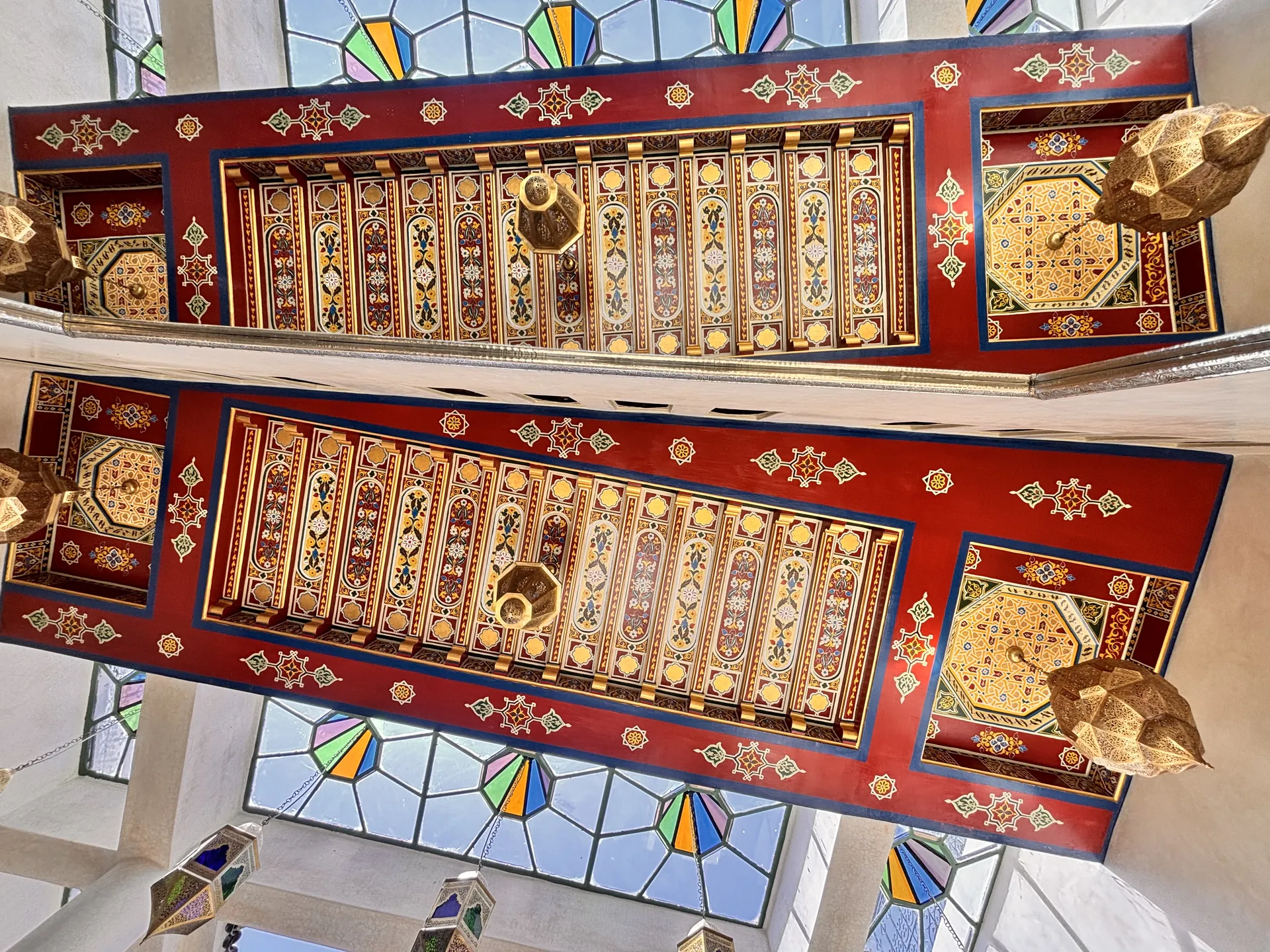 Painted cedar (zouak) ceiling of the gallery, lanterns and stained glass, seen from the patio