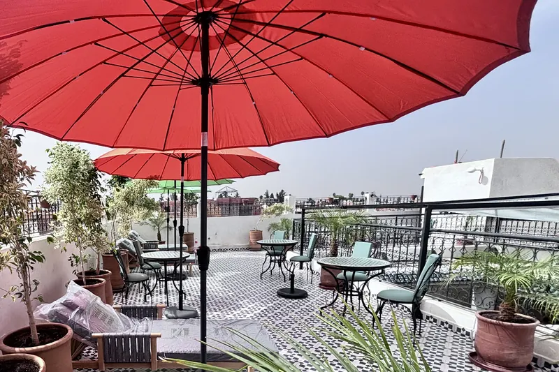 The rooftop terrace under the red parasol, the Médina rooftops beyond