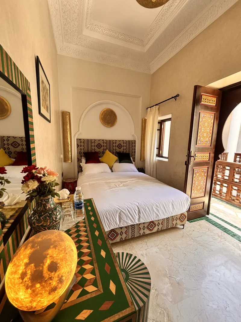 A room: bed, rug and window onto the gallery