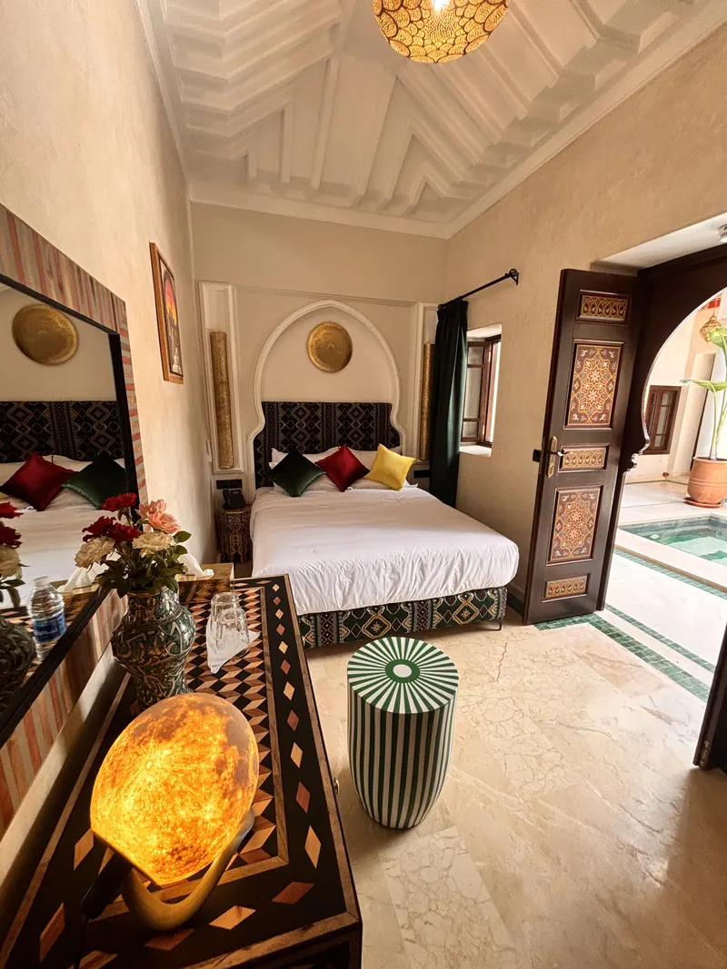 A first-floor room: bed, salt lamp and door open onto the gallery