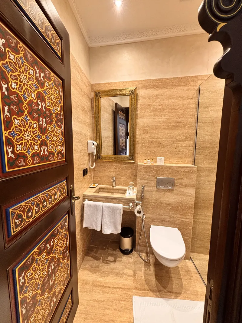 Private bathroom, basin and mirror behind the painted door